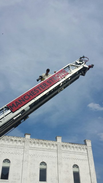 Taking photos from a ladder of a fire truck.